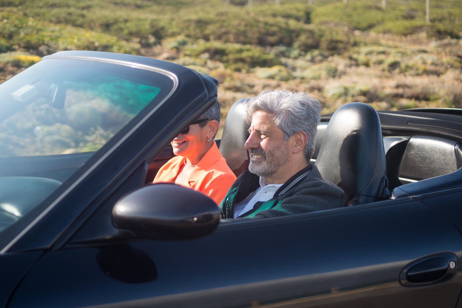 An Elderly Couple Riding a Cabriolet